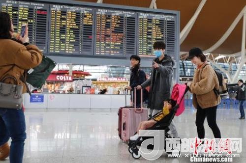 旅客帶著孩子前往辦票柜臺(tái)辦理登機(jī)手續(xù)?！∫罅⑶?攝